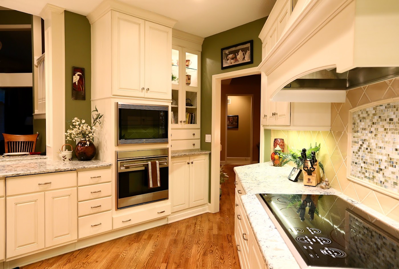 Bright remodeled kitchen with cream cabinetry and a cooktop by Armstrong Kitchens